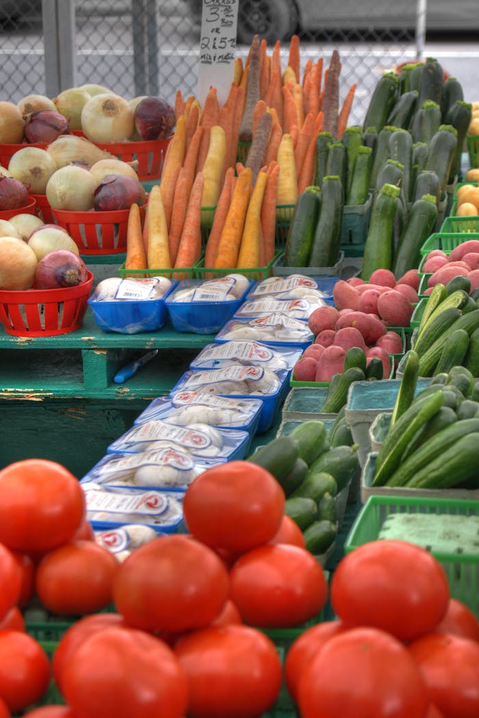 Colorful array of fresh vegetables at an outdoor farmers market stall.