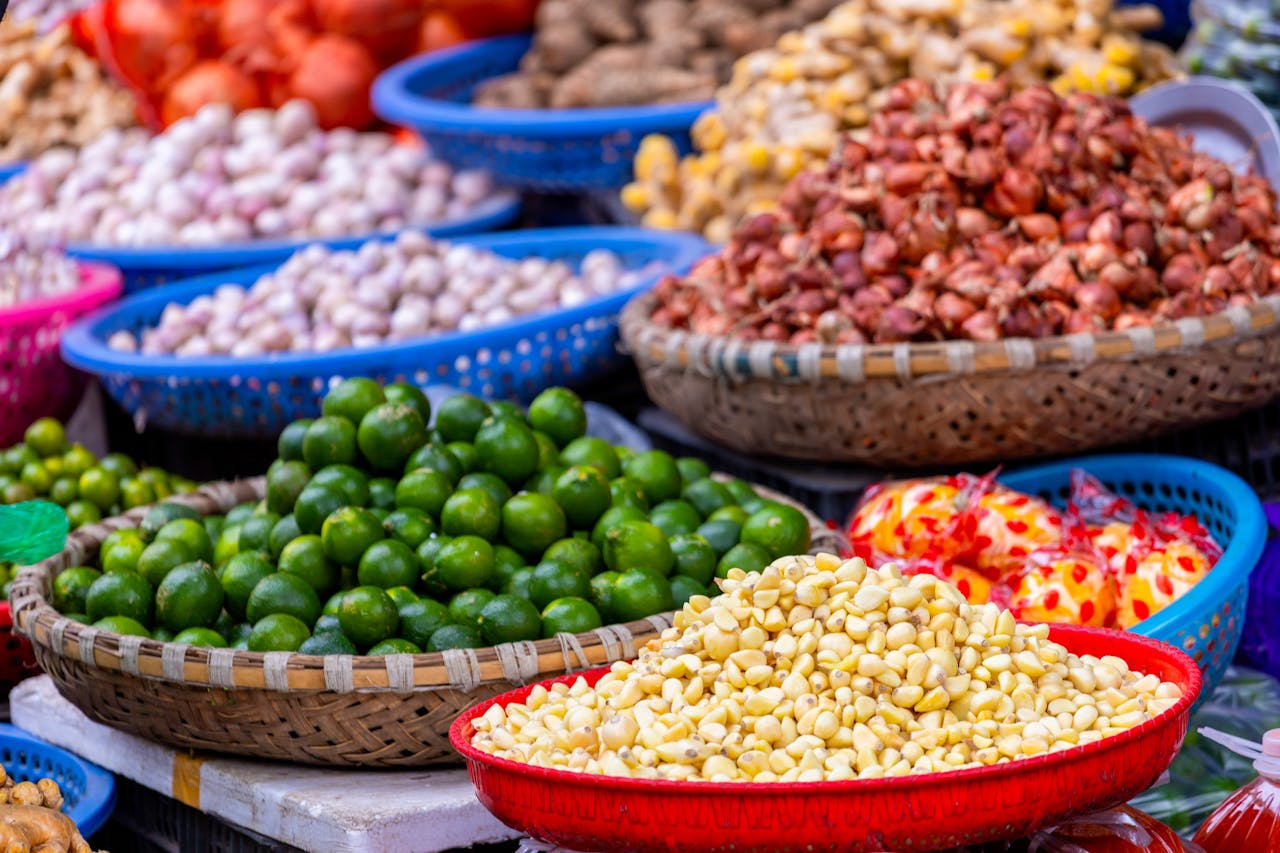 Vibrant display of fresh produce at a market in Hanoi, Vietnam, showcasing limes, garlic, and more.
